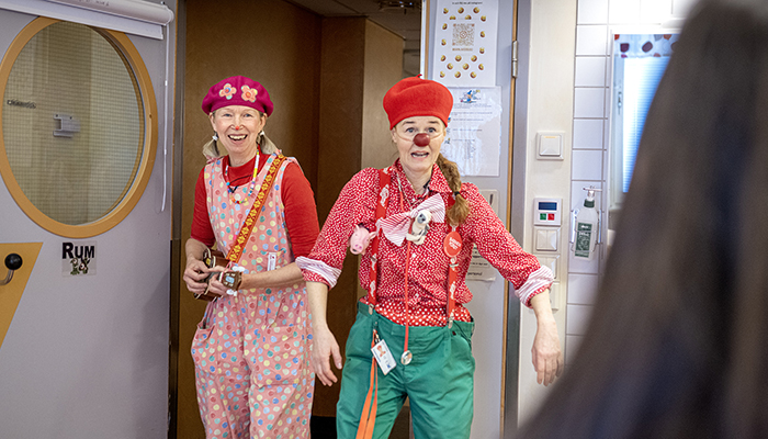 Sjukhusclowner i färgglada kläder och röda näsor