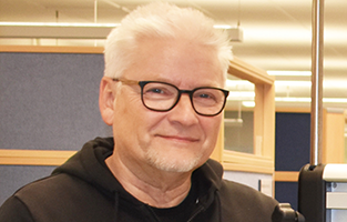 Porträtt på Ronny i mörka glasögon, skägg och ljust hår. 