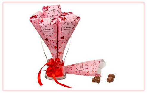 Chokladhjärtan i rosa strut med röda hjärtan