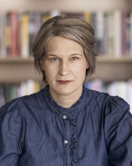 Kajsa Ravin. En kvinna tittar in i kameran. 